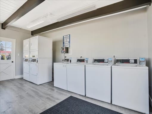 a laundry room with four washers and two dryers