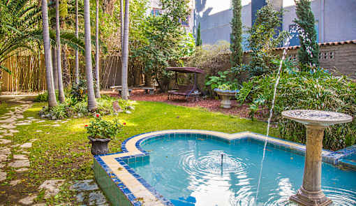 A small pool surrounded by a garden.
