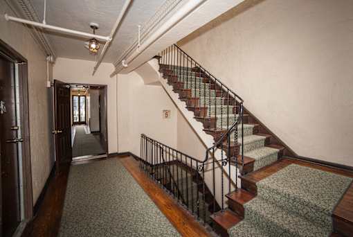 A staircase with a metal railing and wooden steps.