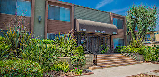 a building with a brown and green facade and a staircase in front of it