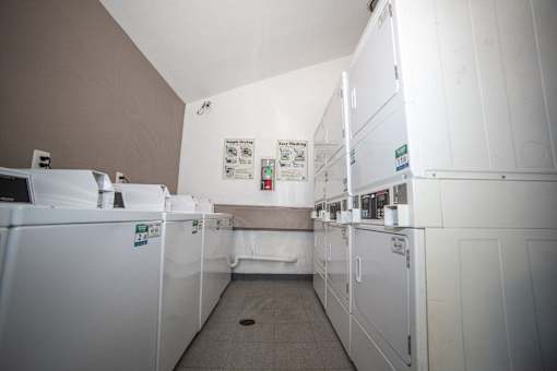 a laundry room with white machines and white walls