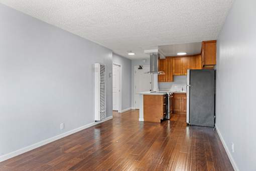 A kitchen with wooden floors and white walls.
