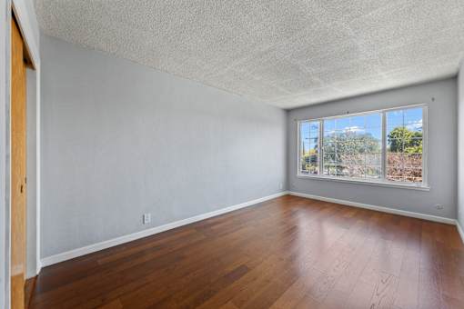 Empty room with wooden floor and white walls.