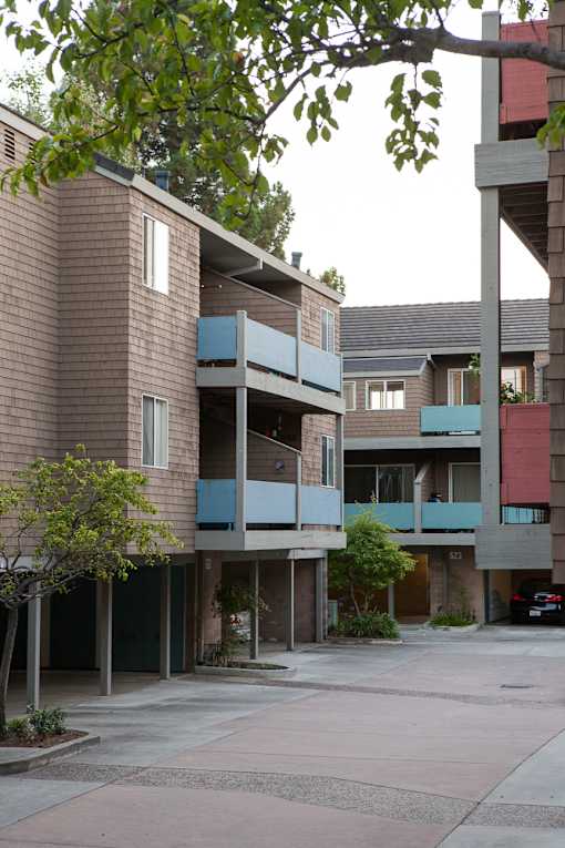 a view of two buildings with balconies and a courtyard