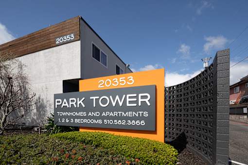 A sign for Park Tower townhouses and apartments with a phone number.
