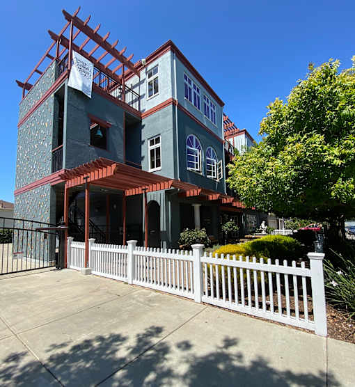 A house under construction with a white picket fence in front.