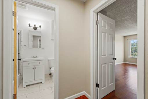 A bathroom with a toilet, sink, and mirror.
