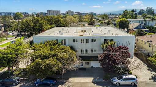 A white building with a parking lot in front of it.