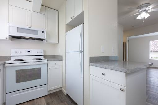 a kitchen with white appliances and white cabinets