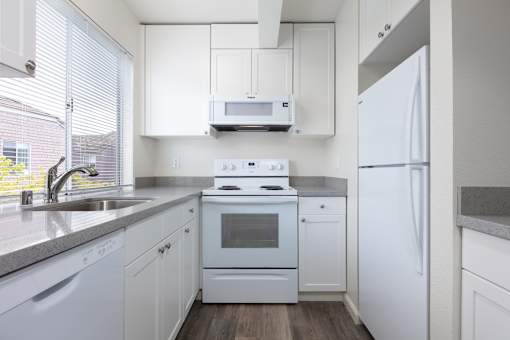 a kitchen with white appliances and white cabinets