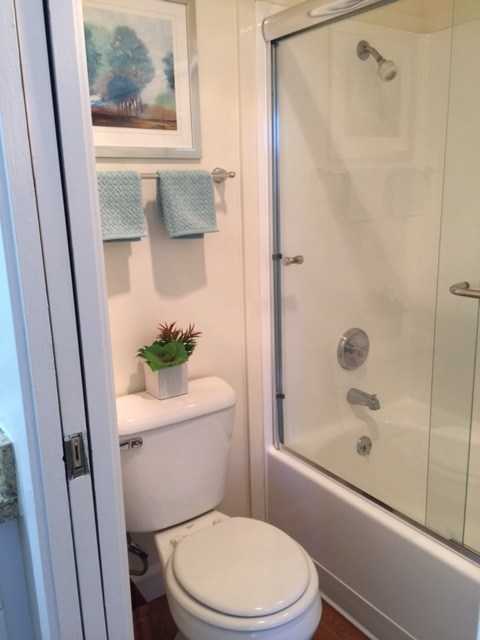 A white toilet sits next to a glass shower door in a bathroom.