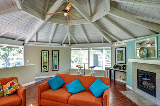 A living room with a fireplace and a ceiling fan.