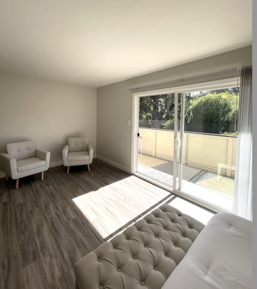 a living room with a couch and chairs and a sliding glass door