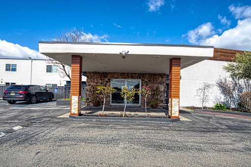 A white building with a brown pillar and a glass door.
