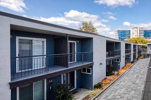 A row of modern townhouses with balconies and doors.