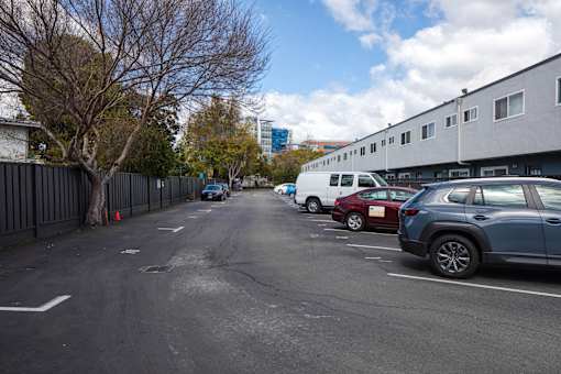 A parking lot with cars and a building in the background.
