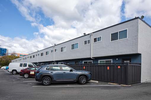 A parking lot with cars and a building in the background.
