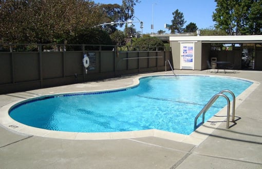 a swimming pool in a backyard with a fence around it