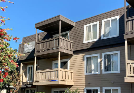 a brown house with a balcony and a blue sky