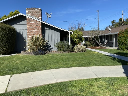 a house with a sidewalk and lawn in front of it