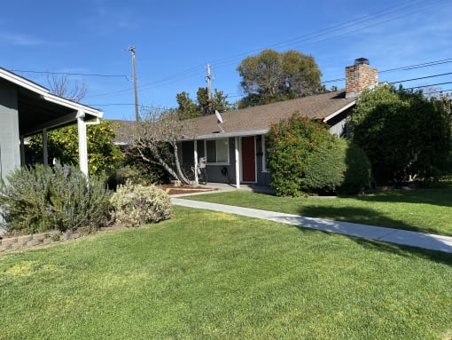 a house with a lawn and a sidewalk in front of it