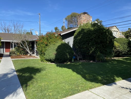 a small house with a yard and a sidewalk