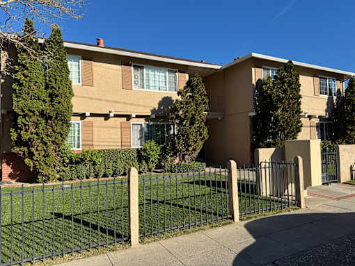 A building with a green fence in front of it.