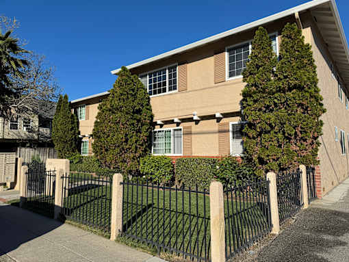 A black metal fence surrounds a building.