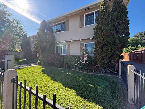 A sunny day at a residential house with a well-maintained lawn.