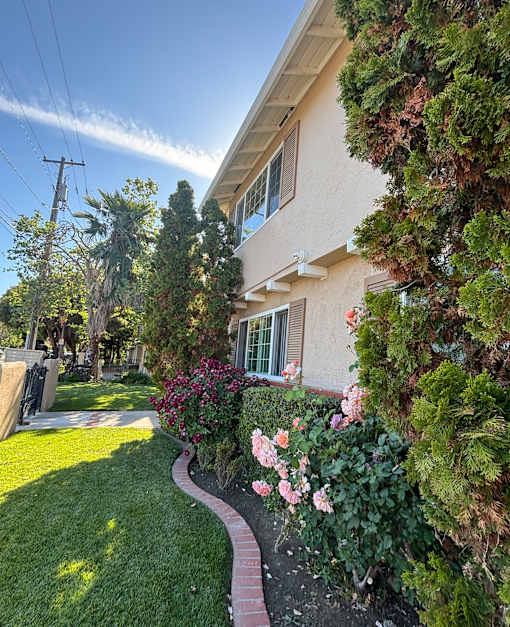 A house with a well-maintained garden in front.