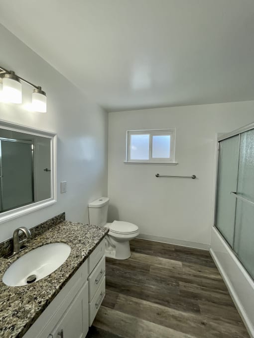 an empty bathroom with a shower toilet and sink