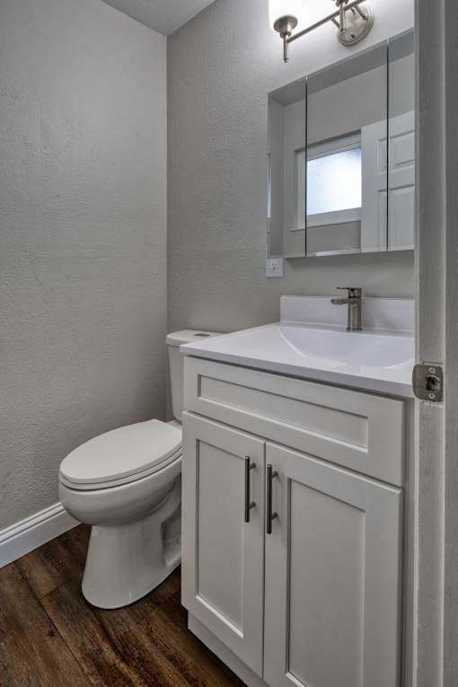A white toilet sits next to a sink in a small bathroom.
