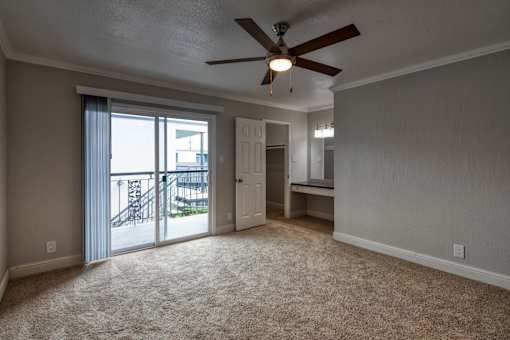 A room with a ceiling fan and carpeted floor.