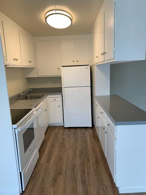 a kitchen with white cabinets and white appliances
