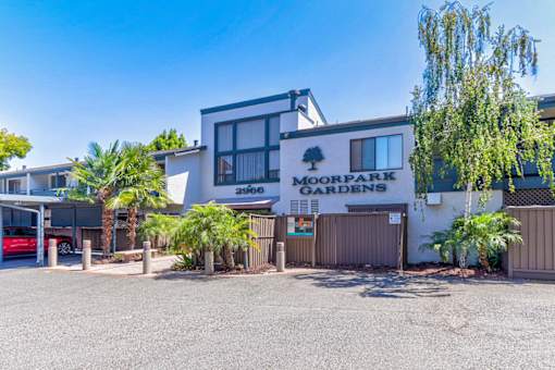 The image shows a building with the sign "Moorpark Gardens" on it.