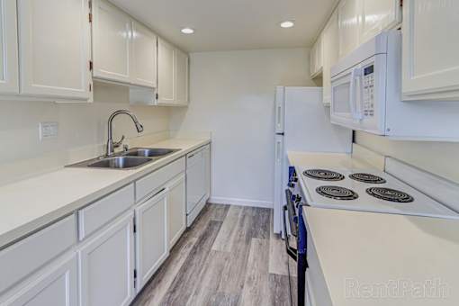 A kitchen with white cabinets and a black stove top.