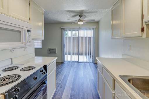 A kitchen with a stove, microwave, and sink.