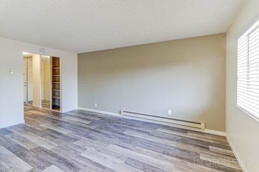 A room with a wooden floor and a white wall.