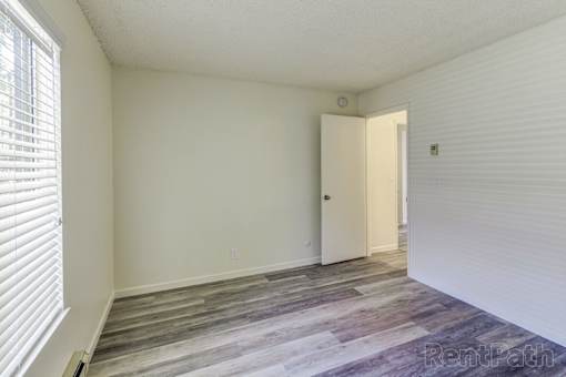 A room with a white door and a window with blinds.