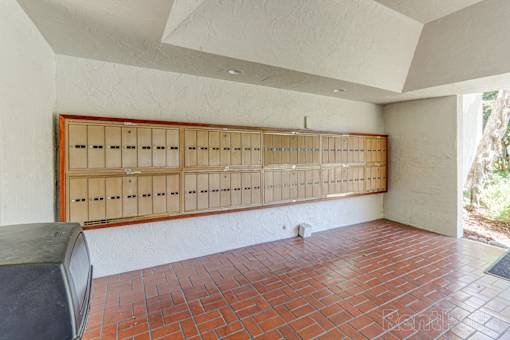 A room with a brick floor and a long wooden cabinet.