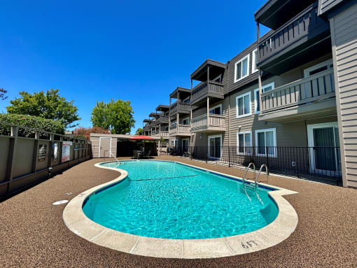 a swimming pool in front of an apartment building