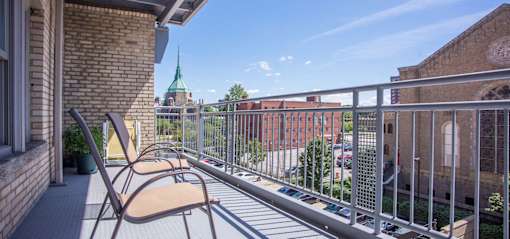 Balcony area of an apartment at Park Lane Villas, fitted with lounge chairs and iron railing.