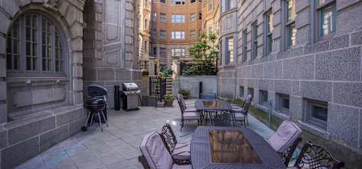Grilling area at Park Lane Villa Apartments fitted with grills, dining tables and chairs, and tiled flooring.