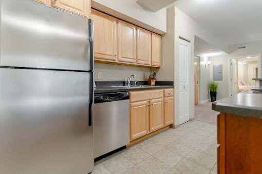 Kitchen area of an apartment fitted with high ceiling, spacious cabinets, and tiled flooring at Park Lane Villa.