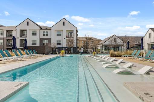 A large swimming pool in front of apartment buildings.