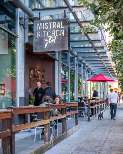 people sitting at tables outside of a restaurant