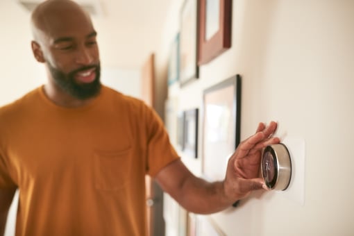 a man is looking at a thermostat on a wall
