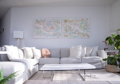 a living room with a couch and a coffee table and two paintings on the wall
