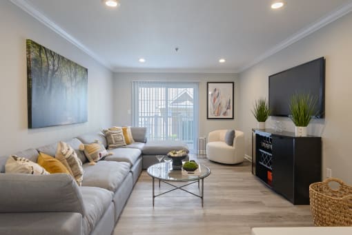 a living room with a large couch and a coffee table in front of a flat screen tv
