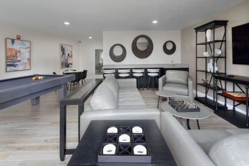 a living room filled with furniture and a pool table